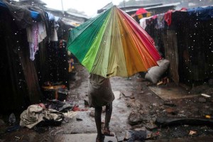 A child carries an umbrella in pouring rain in the slum of Susan's Bay in Sierra Leone's capital Freetown