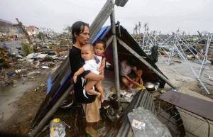 TYPHOON HAIYAN -  father by tent in ruins